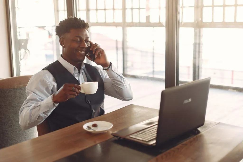 man drinking coffee and answering call