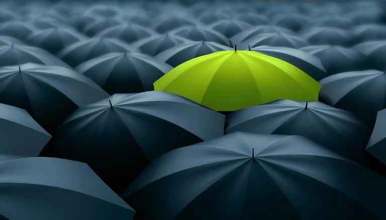 one green umbrella against all black umbrellas